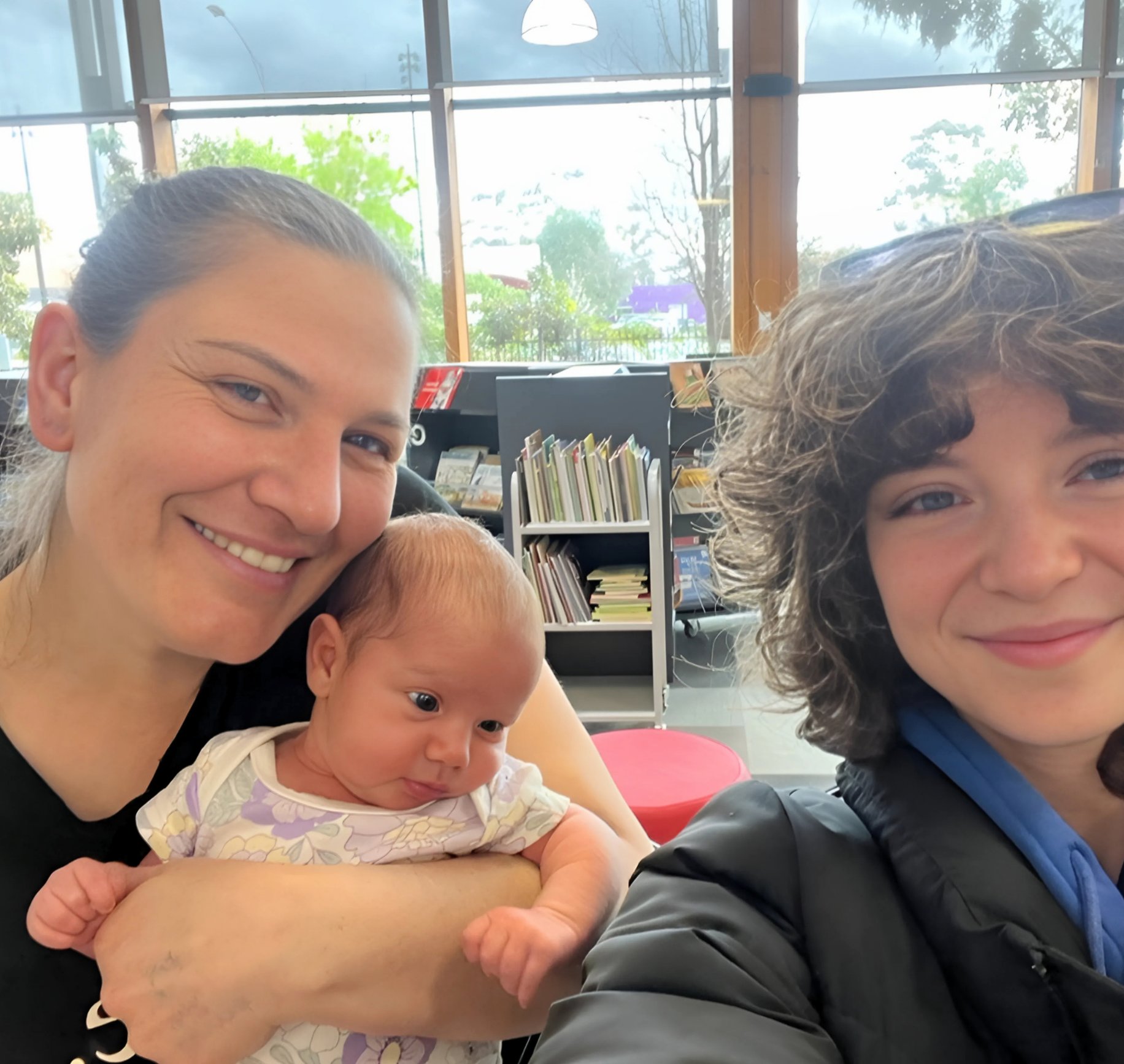 Maddi, student midwife in purple scrubs, with Mel and her baby after birth